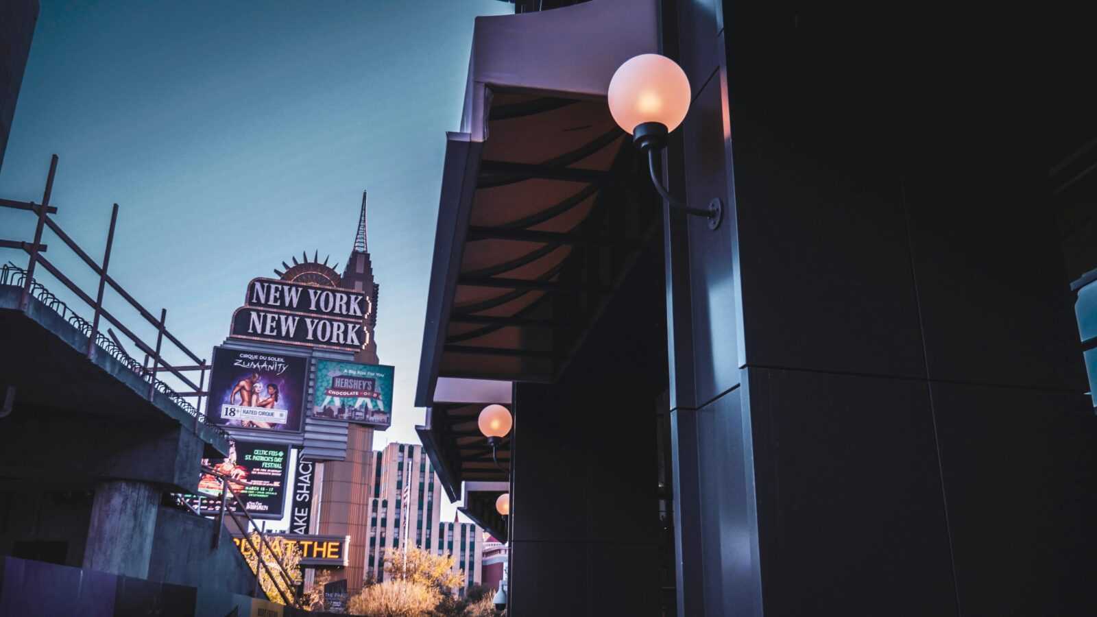 Captivating shot of the New York-New York sign in Las Vegas at twilight, featuring glowing lights and urban architecture.